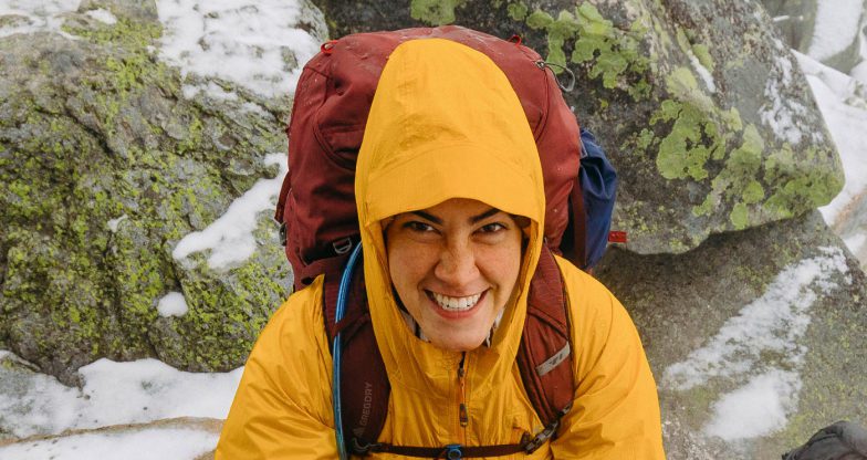 A woman wearing outdoor gear and a backpack